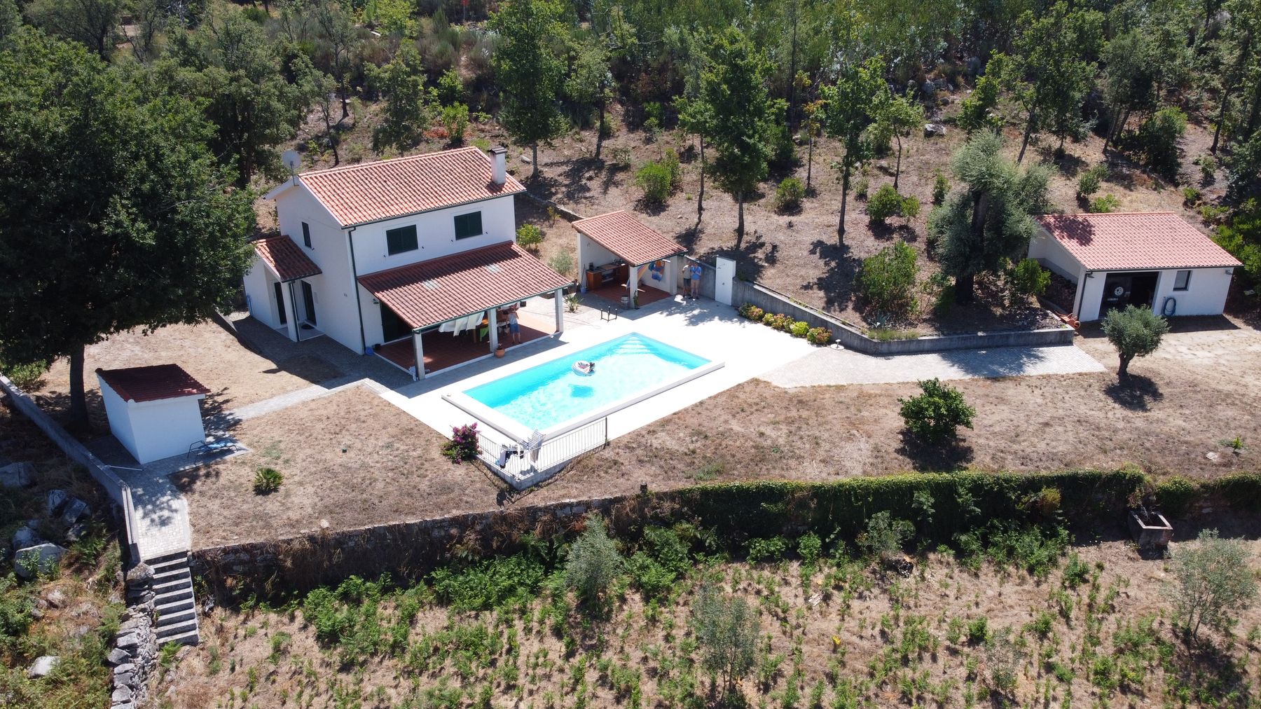 Aerial view of Casa dos Madeiros with the pool, guesthouse and garage, set into the hillside